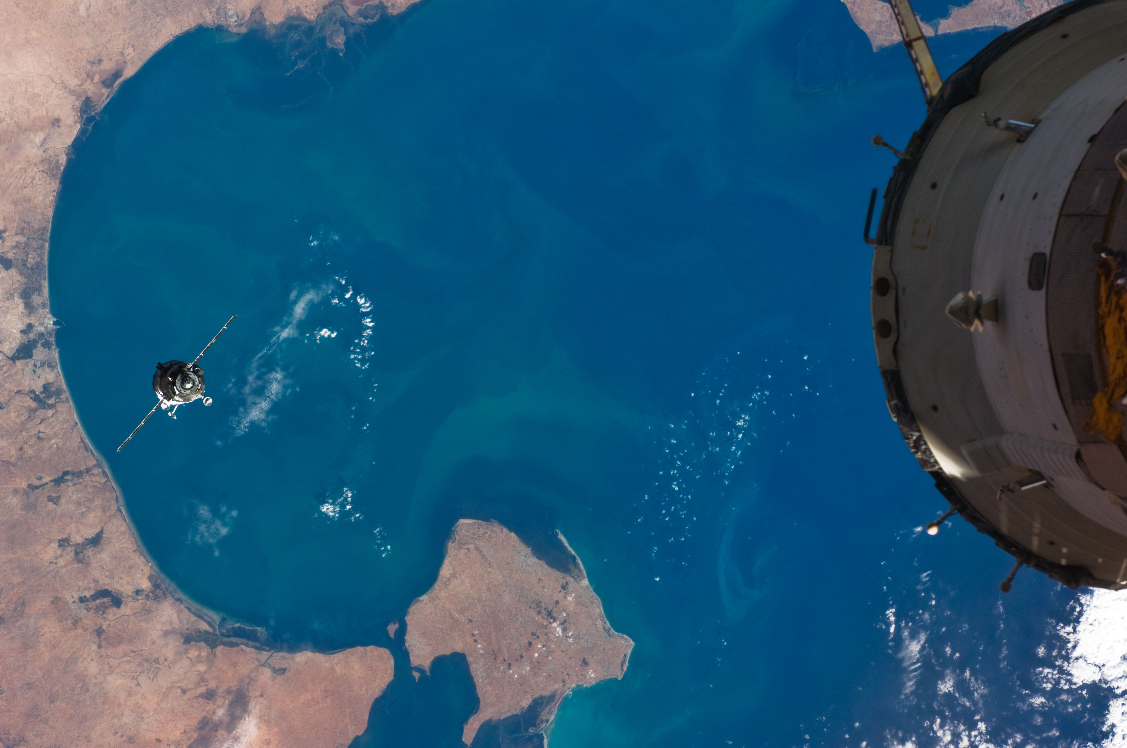 ISS017-E-019541 (14 Oct. 2008) --- The Soyuz TMA-13 spacecraft approaches the International Space Station, carrying NASA astronaut Michael Fincke, Expedition 18 commander; Russian Federal Space Agency cosmonaut Yury Lonchakov, Soyuz commander and flight engineer; and American spaceflight participant Richard Garriott. Fincke and Lonchakov will spend six months on the station, while Garriott will return to Earth on Oct. 23 with two of the Expedition 17 crewmembers currently on the complex. The southeastern coast of Tunisia (left) over the Gulf of Gabes with the Isle of Jerba (bottom-center) forms the backdrop for the scene.