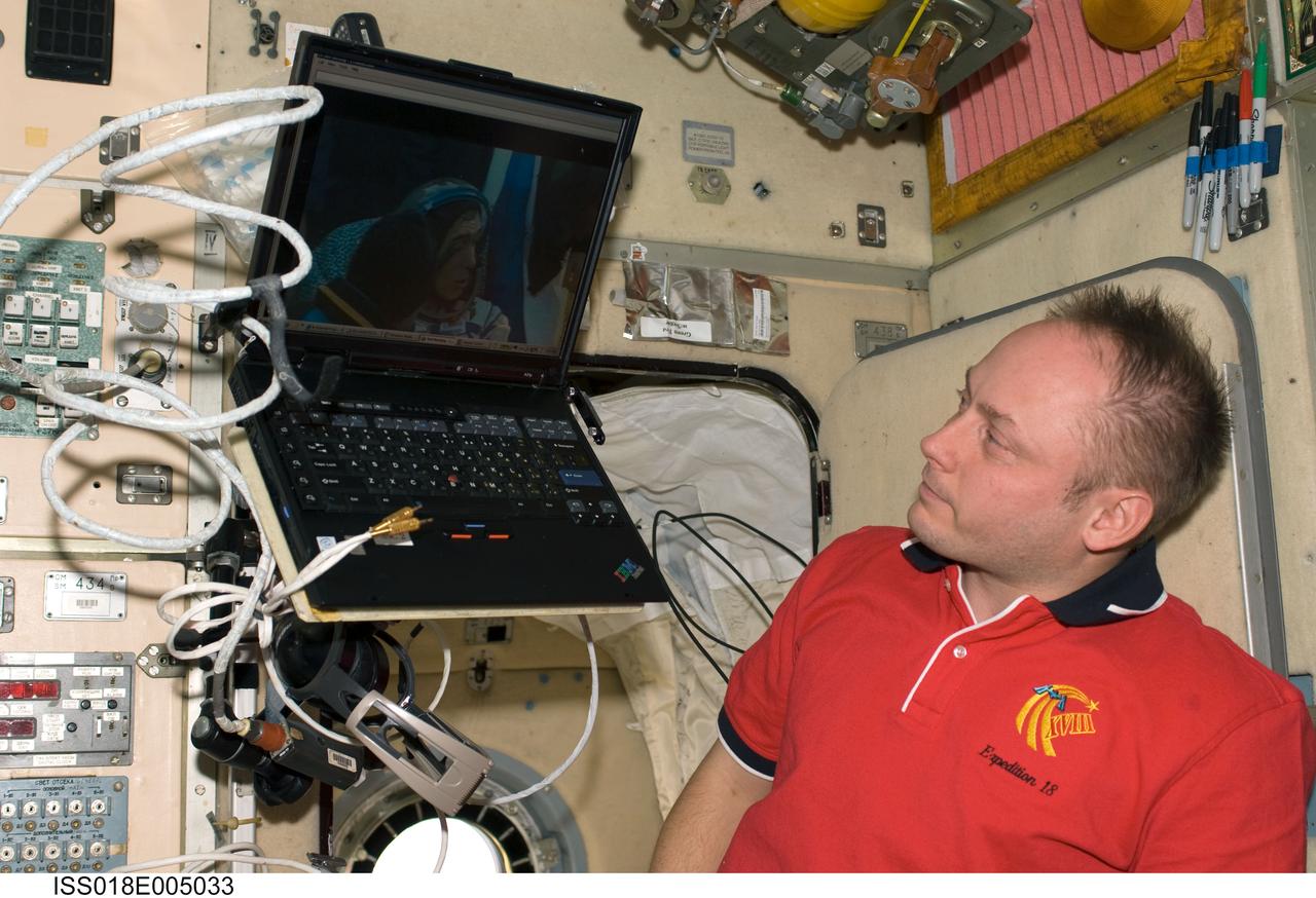 ISS018-E-005033 (23 Oct. 2008) --- Astronaut Michael Fincke, Expedition 18 commander, watches live video of post landing activities on the steppes of Kazakhstan of Expedition 17 crewmembers and spaceflight participant on a computer screen in the Zvezda Service Module of the International Space Station. Cosmonaut Sergei Volkov, Expedition 17 commander, is visible on the screen.