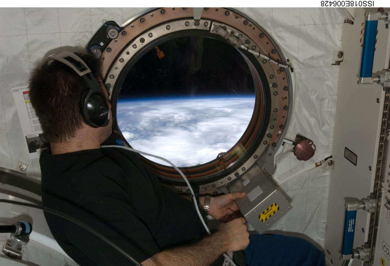 ISS018-E-006428 (2 Nov. 2008) --- Astronaut Greg Chamitoff, Expedition 18 flight engineer, wears a communication system headset while looking through a window in the Kibo laboratory of the International Space Station.