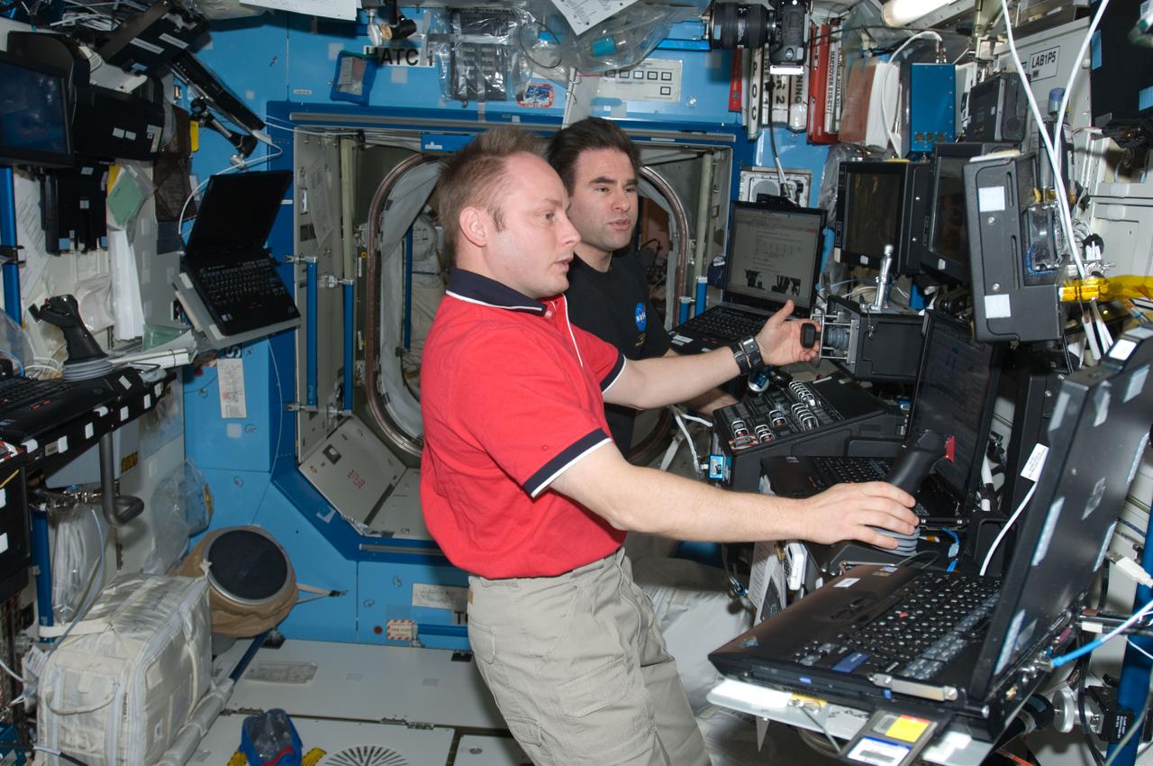 ISS018-E-007817 (5 Nov. 2008) --- Astronauts Michael Fincke (foreground) and Greg Chamitoff, Expedition 18 commander and flight engineer, respectively, work the controls of the Canadarm2 robotic work station in the Destiny laboratory of the International Space Station. Fincke and Chamitoff grappled the External Stowage Platform-3 on the P3 truss and relocated it to a capture attachment mechanism on the Mobile Base System.