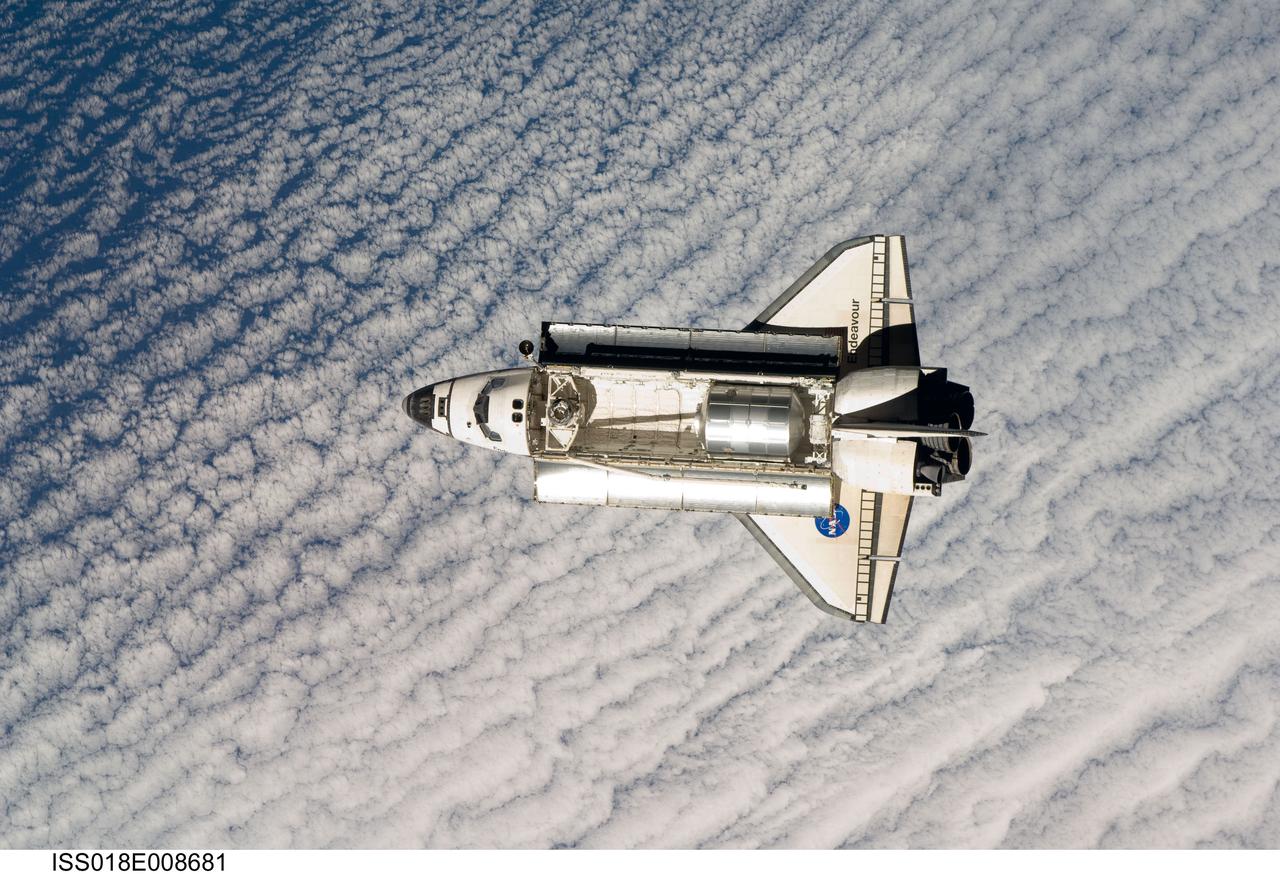 ISS018-E-008681 (16 Nov. 2008) --- Backdropped by a cloud-covered part of Earth, Space Shuttle Endeavour approaches the International Space Station during STS-126 rendezvous and docking operations. Docking occurred at 4:01 p.m. (CST) on Nov. 16, 2008. The Leonardo Multi-Purpose Logistics Module is visible in Endeavour's cargo bay with over 14,000 pounds of cargo for the space station.