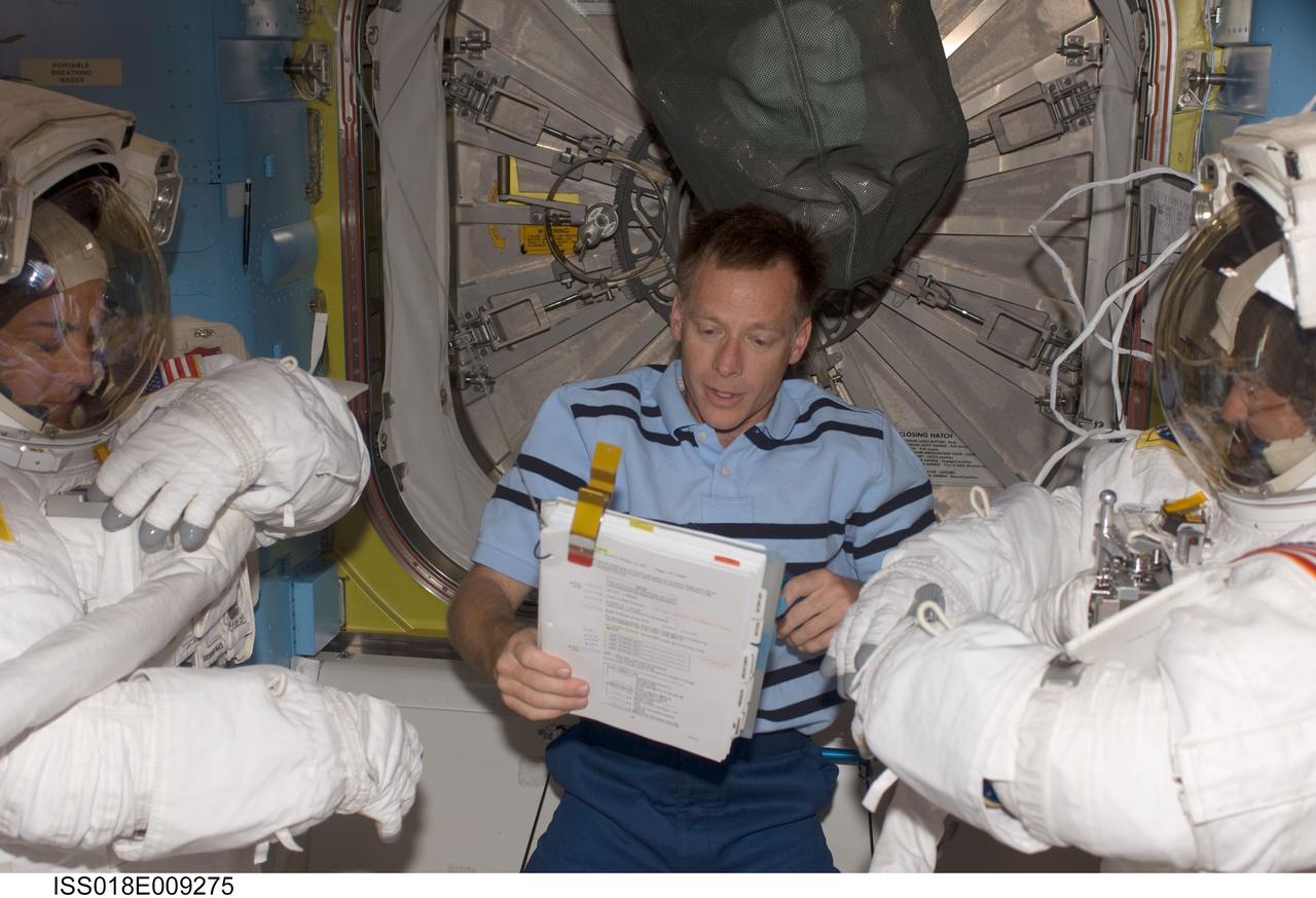 ISS018-E-009275 (18 Nov. 2008) --- Astronauts Heidemarie Stefanyshyn-Piper (left) and Steve Bowen, both STS-126 mission specialists, attired in their Extravehicular Mobility Unit (EMU) spacesuits, prepare for the mission's first scheduled session of extravehicular activity (EVA) in the Quest Airlock of the International Space Station. Astronaut Chris Ferguson, commander, assisted Piper and Bowen.