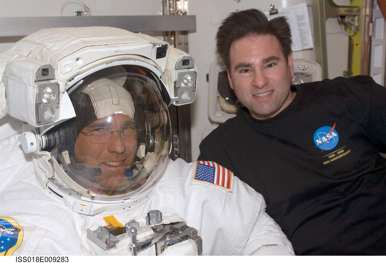 ISS018-E-009283 (18 Nov. 2008) --- Astronauts Steve Bowen (left) and Greg Chamitoff, both STS-126 mission specialists, take a moment for a photo during preparations for the mission's first scheduled session of extravehicular activity (EVA) in the Quest Airlock of the International Space Station. Bowen is attired in his Extravehicular Mobility Unit (EMU) spacesuit.
