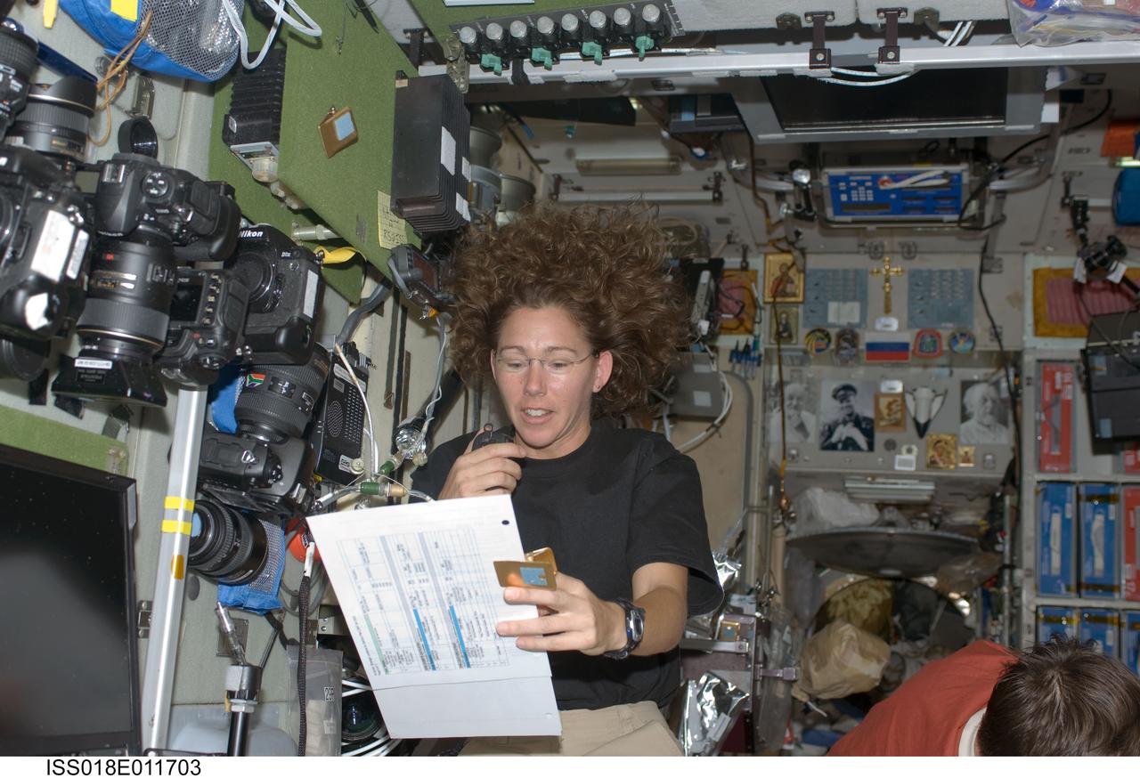 ISS018-E-011703 (9 Dec. 2008) --- Astronaut Sandra Magnus, Expedition 18 flight engineer, uses a communication system while holding a checklist in the Zvezda Service Module of the International Space Station.