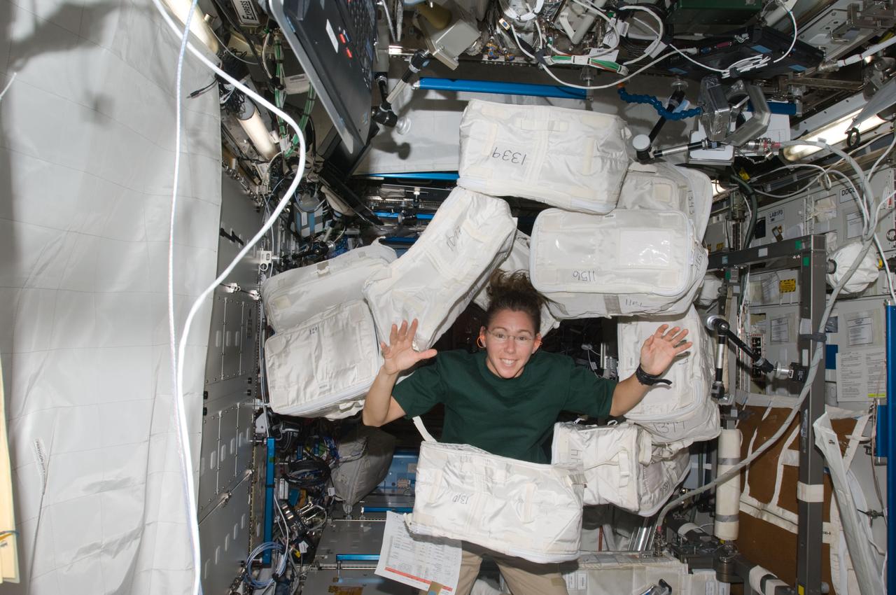 ISS018-E-014682 (22 Dec. 2008) --- Astronaut Sandra Magnus, Expedition 18 flight engineer, is pictured among stowage containers floating freely in the Destiny laboratory of the International Space Station.