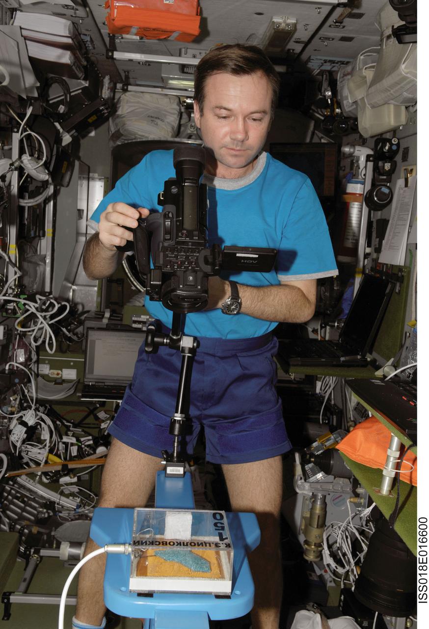 ISS018-E-016600 (5 Jan. 2009) --- Cosmonaut Yury Lonchakov, Expedition 18 flight engineer, configures a video camera for the MATI-75 experiment in the Zvezda Service Module of the International Space Station.