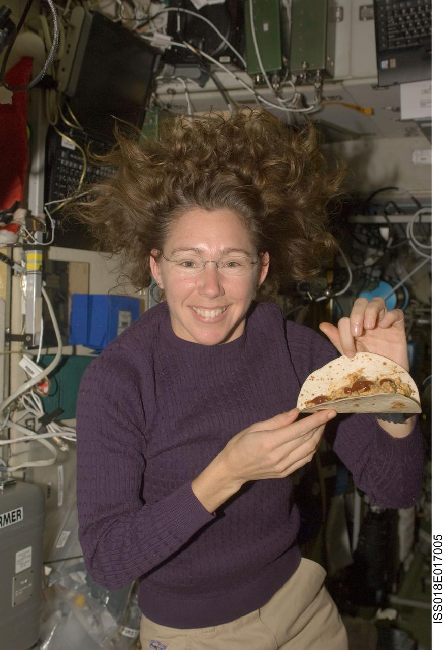 ISS018-E-017005 (1 Jan. 2009) --- Astronaut Sandra Magnus, Expedition 18 flight engineer, poses for a photo with food which she prepared at the galley in the Zvezda Service Module of the International Space Station.