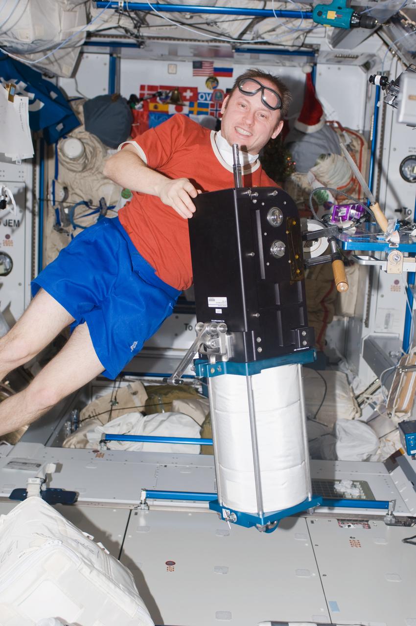 ISS018-E-017129 (1 Jan. 2009) --- Astronaut Michael Fincke, Expedition 18 commander, holds a cylinder flywheel related to the advanced Resistive Exercise Device (aRED) in the Harmony node of the International Space Station.