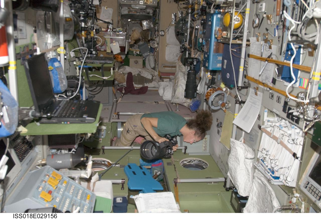 ISS018-E-029156 (9 Feb. 2009) --- Astronaut Sandra Magnus, Expedition 18 flight engineer, holds a still camera while looking through a window in the Zvezda Service Module of the International Space Station.