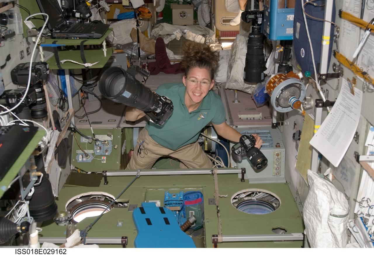 ISS018-E-029162 (9 Feb. 2009) --- Astronaut Sandra Magnus, Expedition 18 flight engineer, smiles for a photo while holding two still cameras in the Zvezda Service Module of the International Space Station.