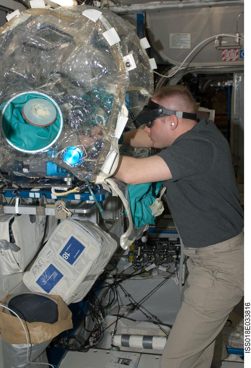 ISS018-E-033816 (19 Feb. 2009) --- Astronaut Michael Fincke, Expedition 18 commander, removes, cleans and replaces electronic test components on a single test card using Component Repair Equipment (CRE-1) hardware in a portable glovebox facility in the Harmony node of the International Space Station. Fincke unsoldered 1 1/2 components from an integrated circuit board and re-soldered new components including an integrated circuit chip.