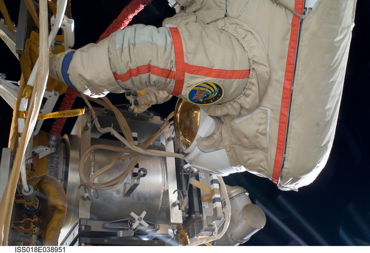 ISS018-E-038951 (10 March 2009) --- Astronaut Michael Fincke, Expedition 18 commander, participates in a session of extravehicular activity (EVA) to perform maintenance on the International Space Station. During the 4-hour, 49-minute spacewalk, Fincke and cosmonaut Yury Lonchakov (out of frame) reinstalled the Exposing Specimens of Organic and Biological Materials to Open Space (Expose-R) experiment on the universal science platform mounted to the exterior of the Zvezda Service Module. The spacewalkers also removed straps, or tape, from the area of the docking target on the Pirs airlock and docking compartment. The tape was removed to ensure it does not get in the way during the arrival of visiting Soyuz or Progress spacecraft.