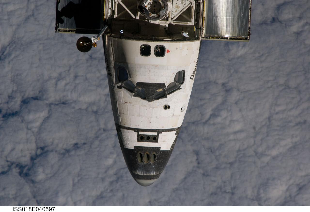 ISS018-E-040597 (17 March 2009) --- An overhead view of the exterior of Space Shuttle Discovery's crew cabin, part of its payload bay doors and docking system was provided by Expedition 18 crewmembers on the International Space Station. Before docking with the station, astronaut Lee Archambault, STS-119 commander, flew the shuttle through a Rendezvous Pitch Maneuver or basically a backflip to allow the space station crew a good view of Discovery's heat shield. Using digital still cameras equipped with both 400 and 800 millimeter lenses, the ISS crewmembers took a number of photos of the shuttle's thermal protection system and sent them down to teams on the ground for analysis. A 800 millimeter lens was used for this image.