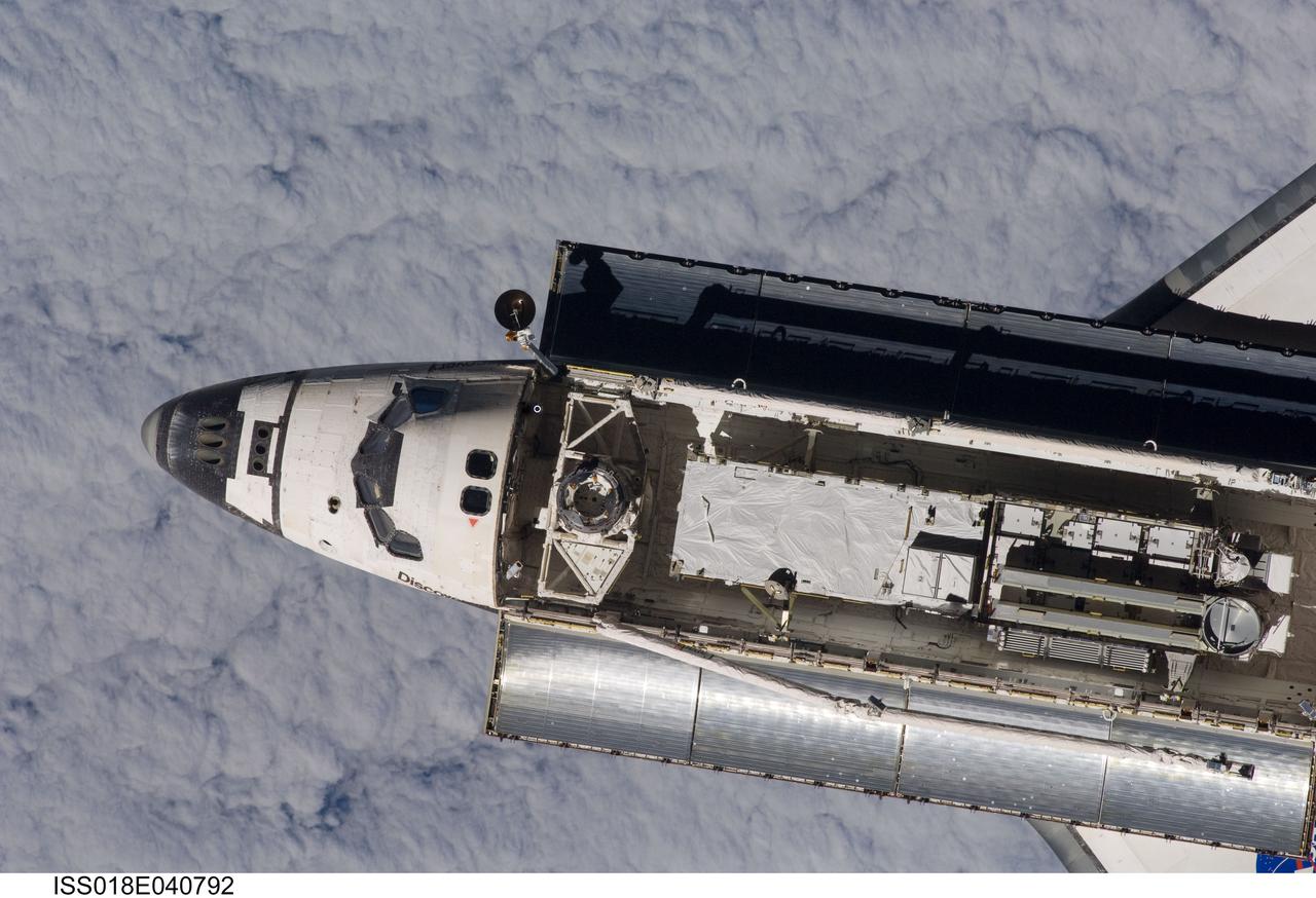 ISS018-E-040792 (17 March 2009) --- Backdropped by a blanket of clouds, Space Shuttle Discovery is featured in this image photographed by an Expedition 18 crewmember on the International Space Station during rendezvous and docking operations. Before docking with the station, astronaut Lee Archambault, STS-119 commander, flew the shuttle through a Rendezvous Pitch Maneuver or basically a backflip to allow the space station crew a good view of Discovery's heat shield. Using digital still cameras equipped with both 400 and 800 millimeter lenses, the ISS crewmembers took a number of photos of the shuttle's thermal protection system and sent them down to teams on the ground for analysis. A 400 millimeter lens was used for this image. Docking occurred at 4:20 p.m. (CDT) on March 17, 2009. The final pair of power-generating solar array wings and the S6 truss segment are visible in Discovery?s cargo bay.