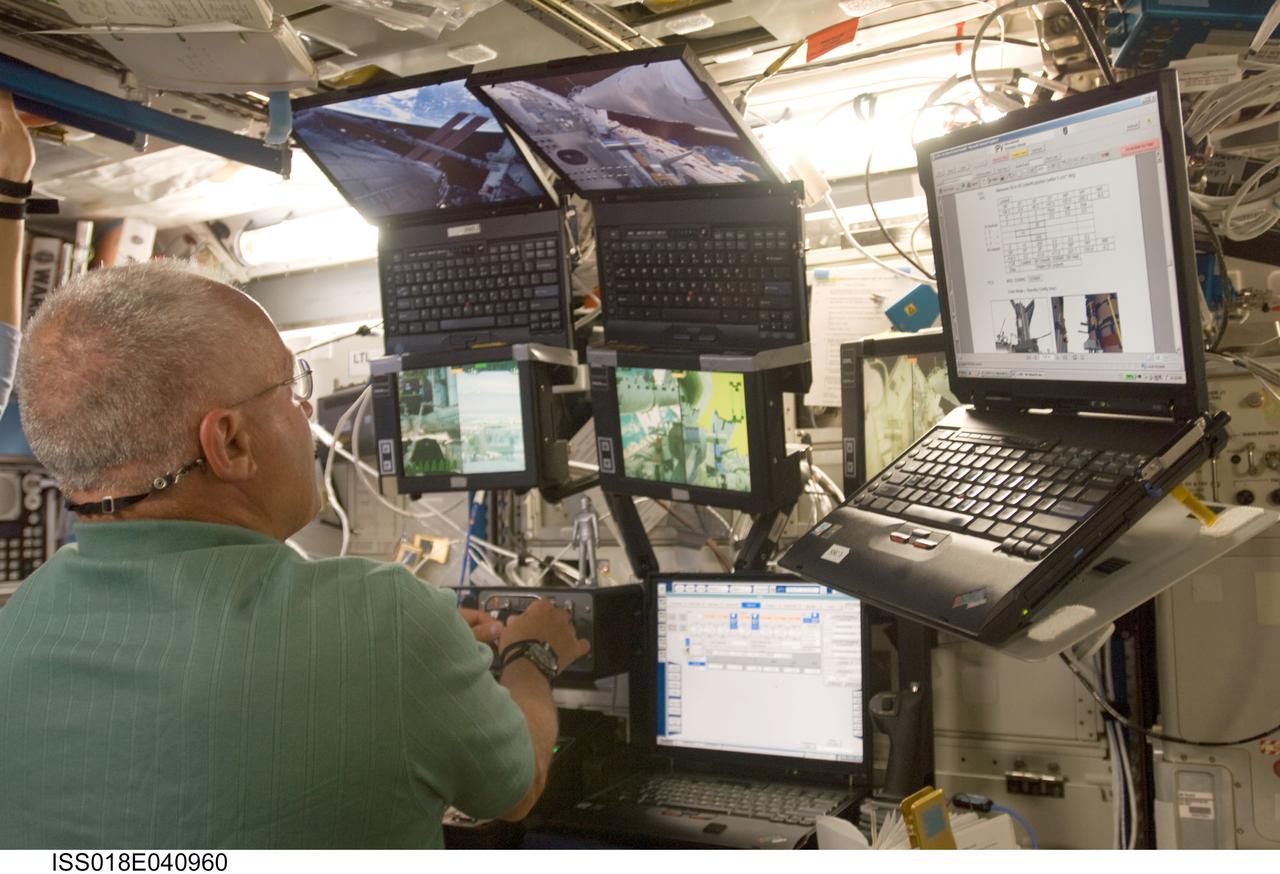 ISS018-E-040960 (18 March 2009) --- Astronaut John Phillips, STS-119 mission specialist, works the controls of the station's robotic Canadarm2 in the Destiny laboratory of the International Space Station while Space Shuttle Discovery is docked with the station.