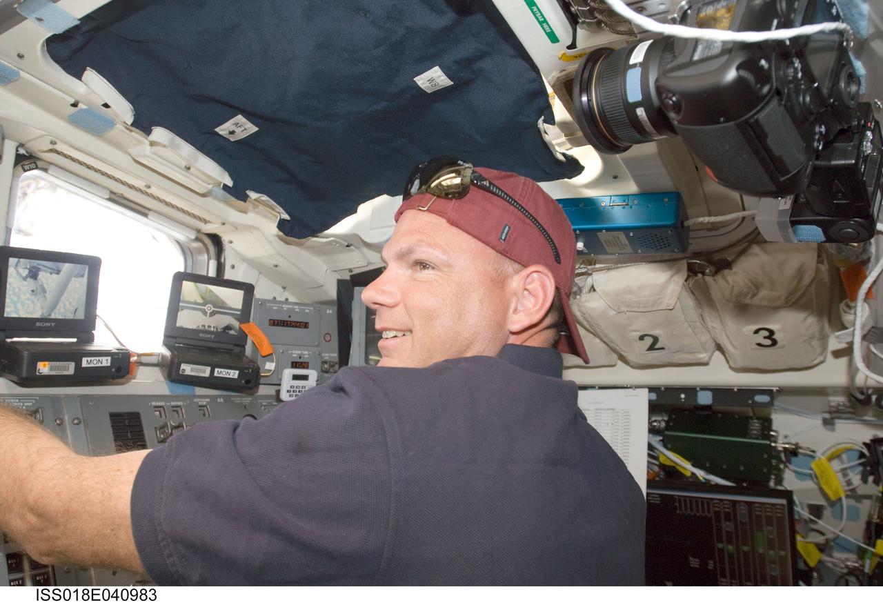 ISS018-E-040983 (18 March 2009) --- Astronaut Tony Antonelli, STS-119 pilot, works controls on the aft flight deck of Space Shuttle Discovery while docked with the International Space Station.