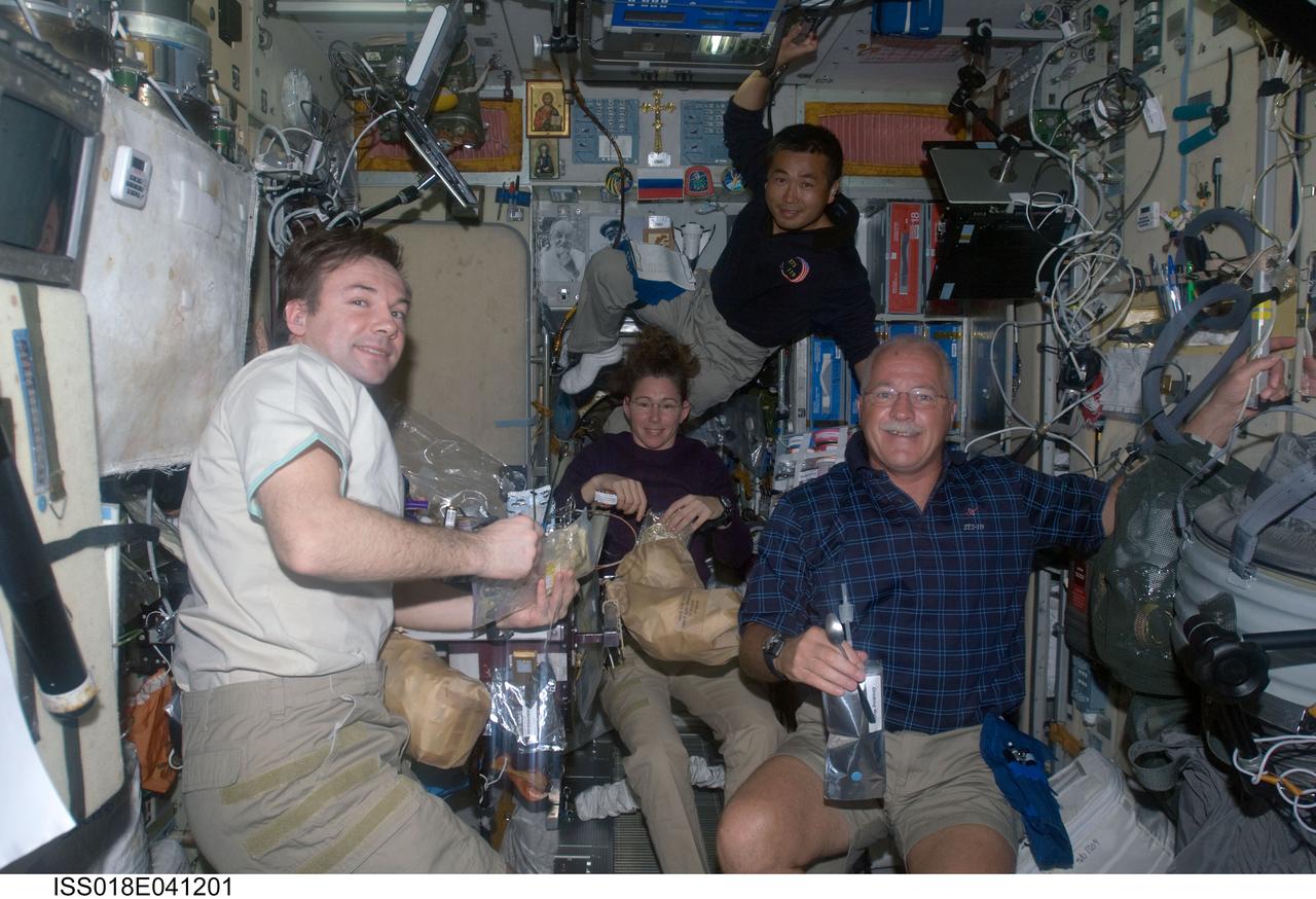 ISS018-E-041201 (19 March 2009) --- Crewmembers on the International Space Station share a meal in the Zvezda Service Module while Space Shuttle Discovery remains docked with the station. Pictured (from the left) are cosmonaut Yury Lonchakov, Expedition 18 flight engineer; NASA astronaut Sandra Magnus, STS-119 mission specialist; Japan Aerospace Exploration Agency (JAXA) astronaut Koichi Wakata, Expedition 18 flight engineer; and NASA astronaut John Phillips, STS-119 mission specialist.