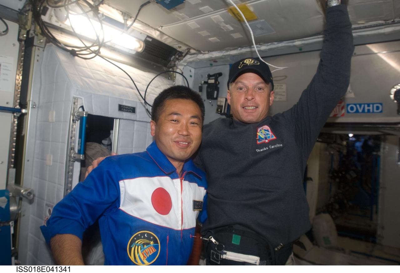 ISS018-E-041341 (20 March 2009) --- Japan Aerospace Exploration Agency (JAXA) astronaut Koichi Wakata, Expedition 18 flight engineer; and NASA astronaut Steve Swanson, STS-119 mission specialist, pose for a photo near Wakata?s crew compartment in the Harmony node of the International Space Station while Space Shuttle Discovery remains docked with the station.