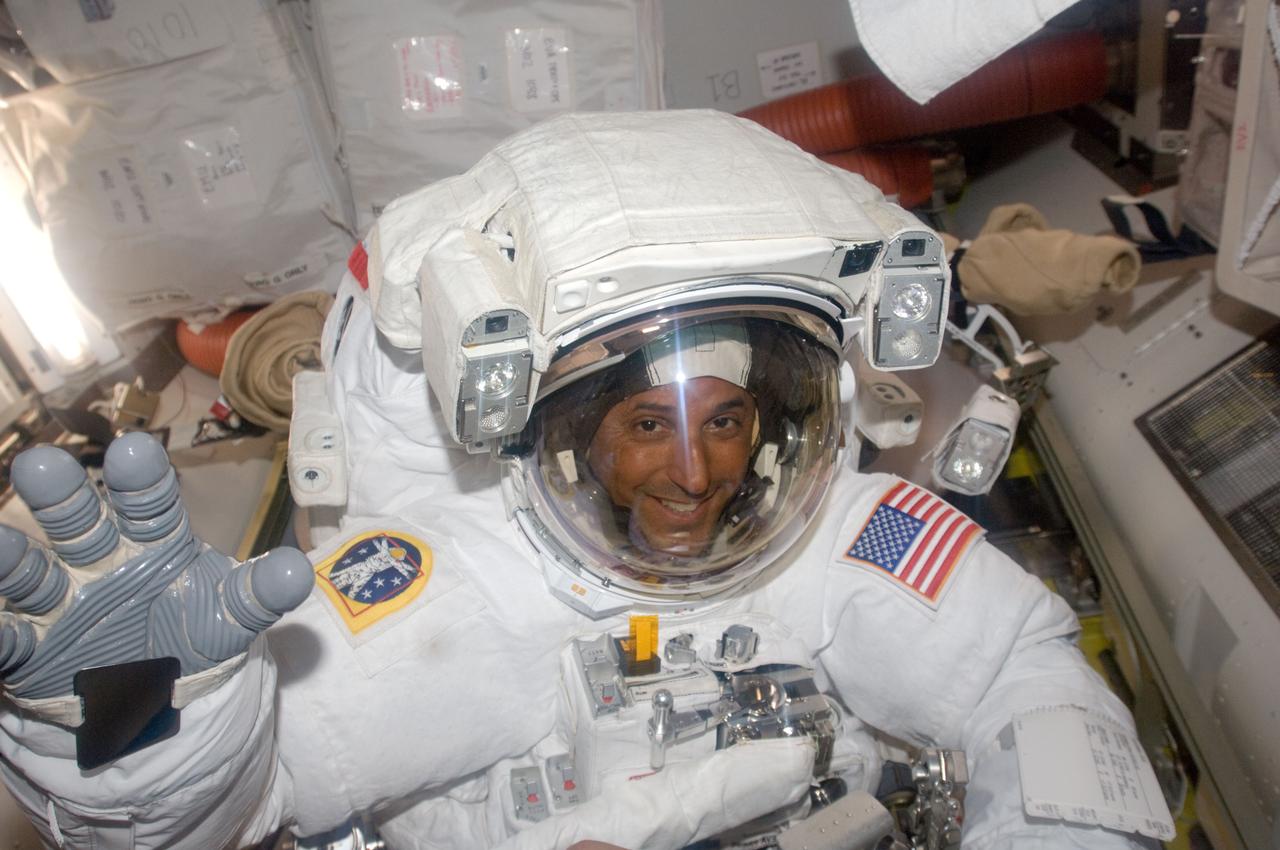ISS018-E-041348 (21 March 2009) --- Astronaut Joseph Acaba, STS-119 mission specialist, attired in his Extravehicular Mobility Unit (EMU) spacesuit, waves as he prepares to leave the Quest Airlock of the International Space Station to begin the mission's second session of extravehicular activity (EVA).