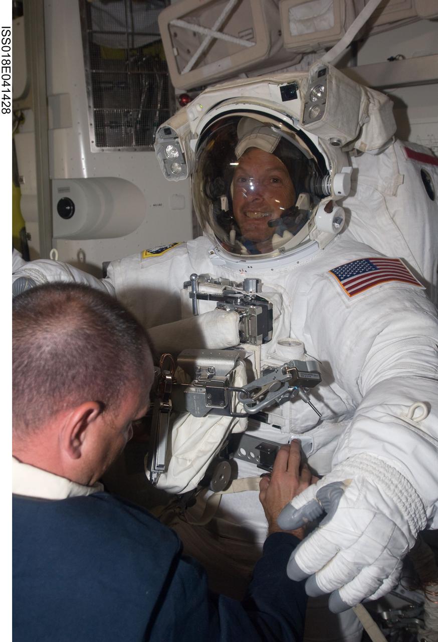 ISS018-E-041428 (21 March 2009) --- Attired in his Extravehicular Mobility Unit (EMU) spacesuit, astronaut Steve Swanson, STS-119 mission specialist, is pictured in the Quest Airlock of the International Space Station as the mission's second session of extravehicular activity (EVA) draws to a close. Astronaut Tony Antonelli, STS-119 pilot, assists with the doffing of the spacesuit.