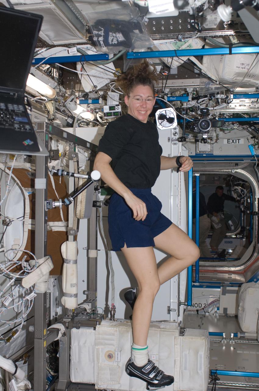 ISS018-E-042649 (22 March 2009) --- Astronaut Sandra Magnus, STS-119 mission specialist, exercises on the Cycle Ergometer with Vibration Isolation System (CEVIS) in the Destiny laboratory of the International Space Station while Space Shuttle Discovery remains docked with the station.