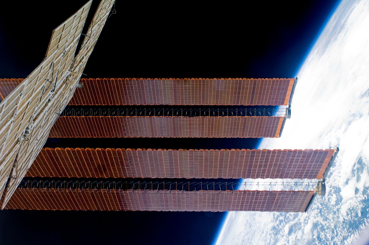 ISS018-E-042659 (22 March 2009) --- Station solar array panels and Earth's horizon are featured in this image photographed by an Expedition 18 crewmember on the International Space Station while Space Shuttle Discovery (STS-119) remains docked with the station.