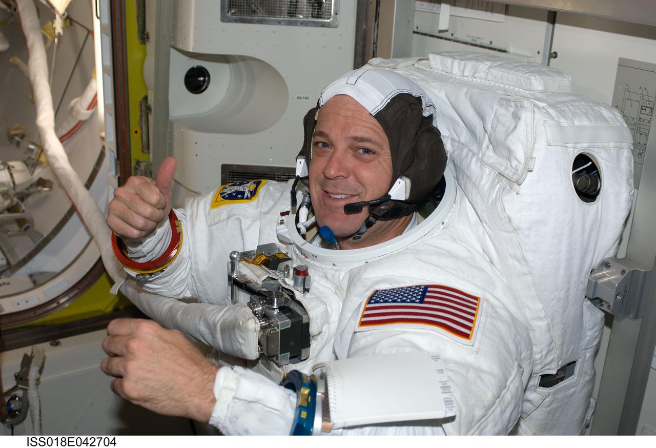 ISS018-E-042704 (23 March 2009) --- Astronaut Richard Arnold, STS-119 mission specialist, attired in his Extravehicular Mobility Unit (EMU) spacesuit, gives a ?thumbs-up? signal as he prepares for the mission's third scheduled session of extravehicular activity (EVA) in the Quest Airlock of the International Space Station.