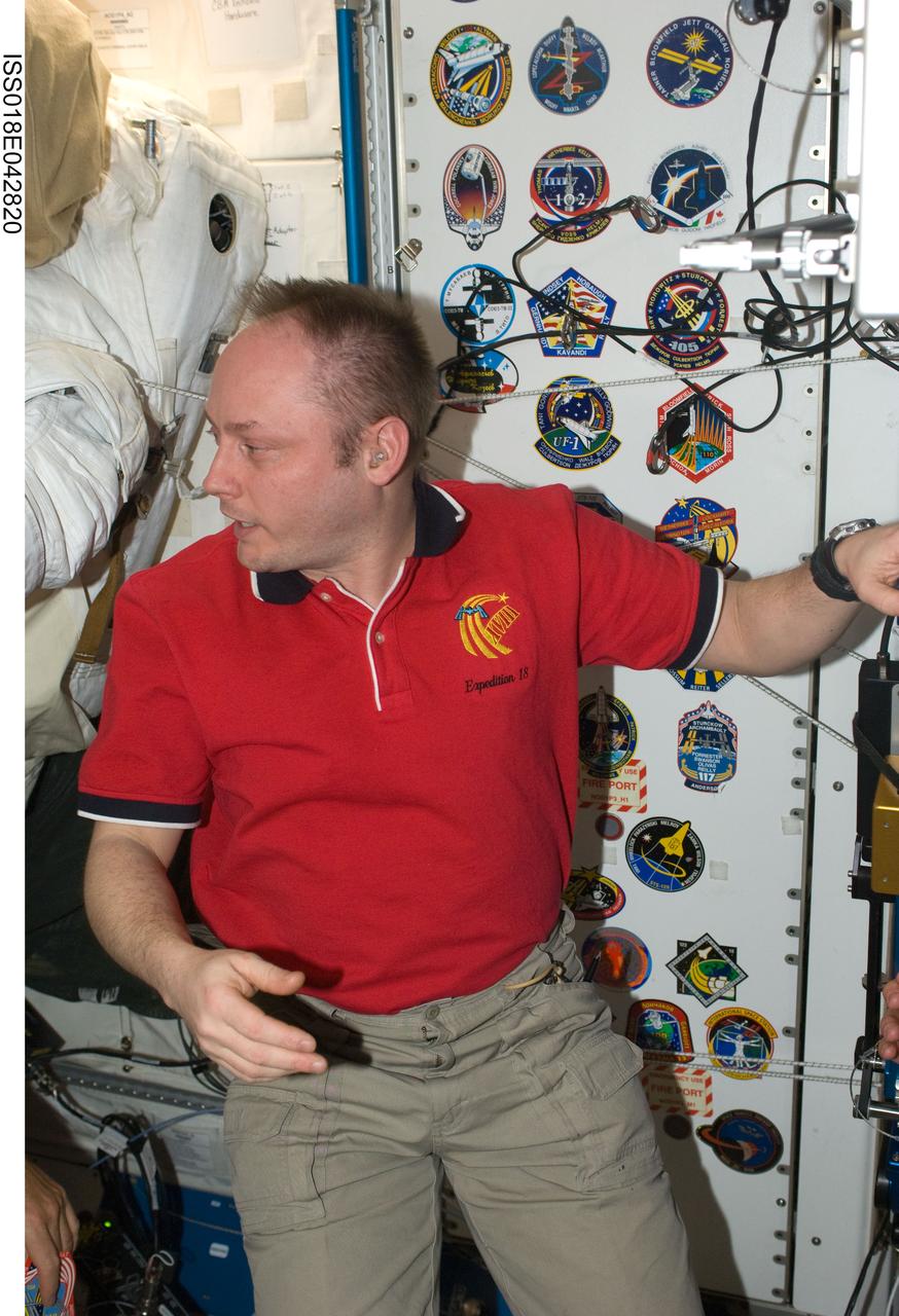 ISS018-E-042820 (24 March 2009) --- Astronaut Michael Fincke, Expedition 18 commander, is pictured in the Unity node of the International Space Station while Space Shuttle Discovery (STS-119) remains docked with the station. Visible behind Fincke are various crew patches of those representing shuttle crews who have worked on the ISS.