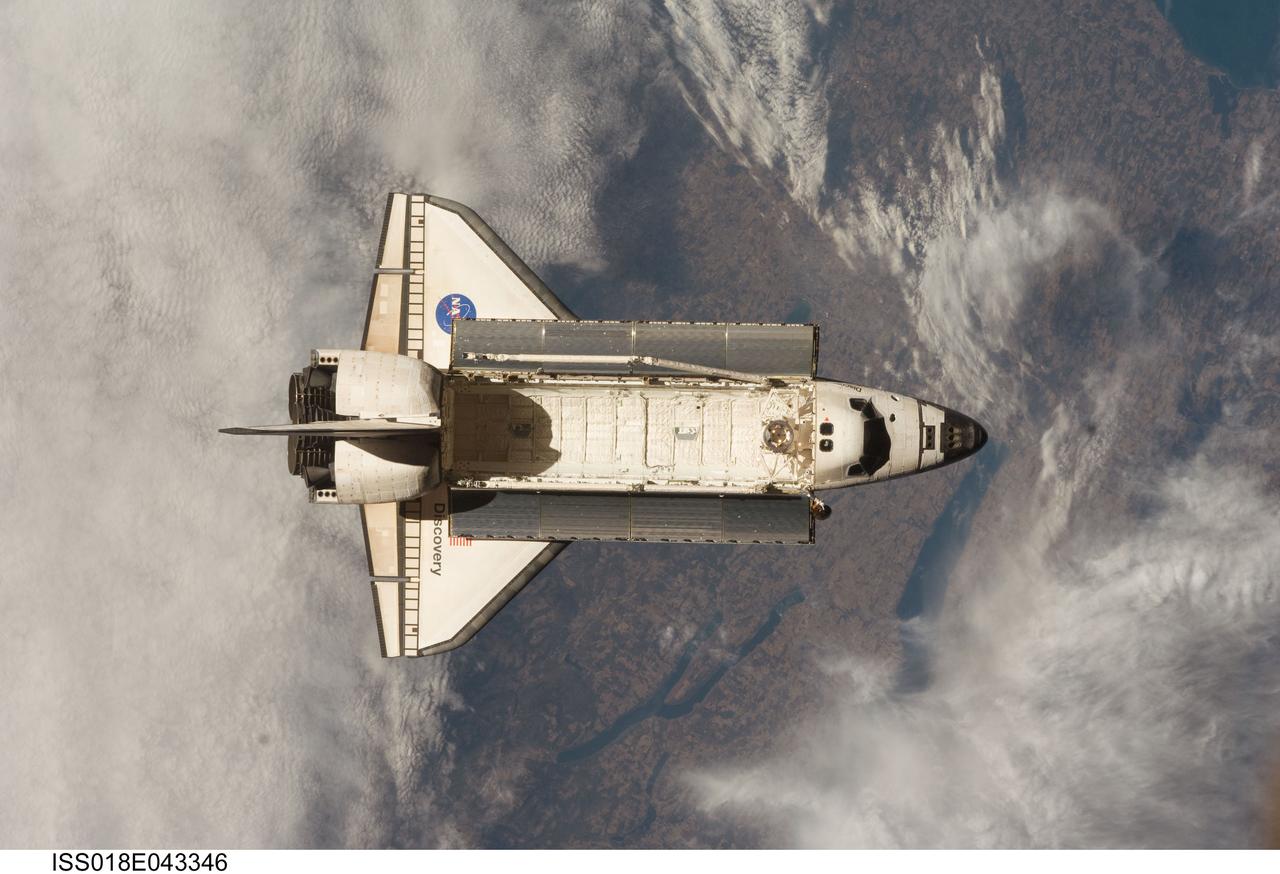 ISS018-E-043346 (25 March 2009) --- Backdropped by a colorful Earth, Space Shuttle Discovery (STS-119) is featured in this image photographed by an Expedition 18 crew member on the International Space Station soon after the shuttle and station began their post-undocking relative separation on March 25, 2009.
