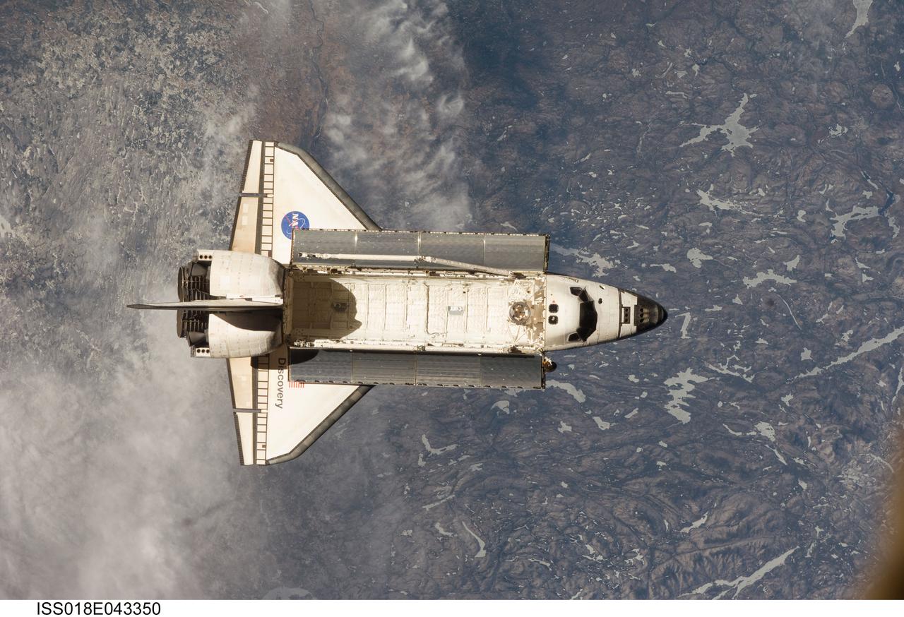 ISS018-E-043350 (25 March 2009) --- Backdropped by a colorful Earth, Space Shuttle Discovery (STS-119) is featured in this image photographed by an Expedition 18 crew member on the International Space Station soon after the shuttle and station began their post-undocking relative separation on March 25, 2009.