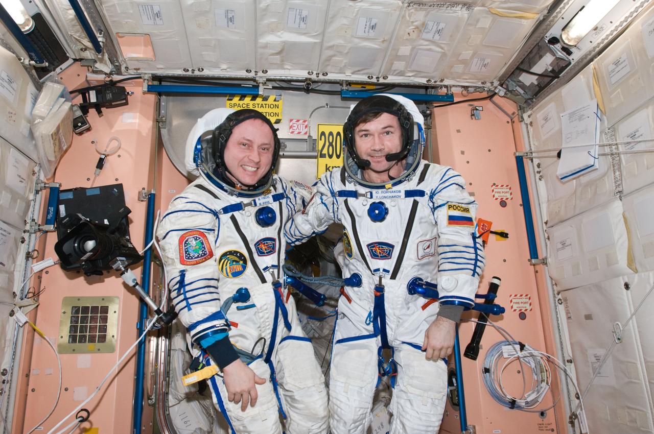 ISS018-E-043378 (26 March 2009) --- NASA astronaut Michael Fincke (left), Expedition 18 commander; and cosmonaut Yury Lonchakov, flight engineer, attired in their Russian Sokol flight suits, pose for a photo in the Unity node of the International Space Station.
