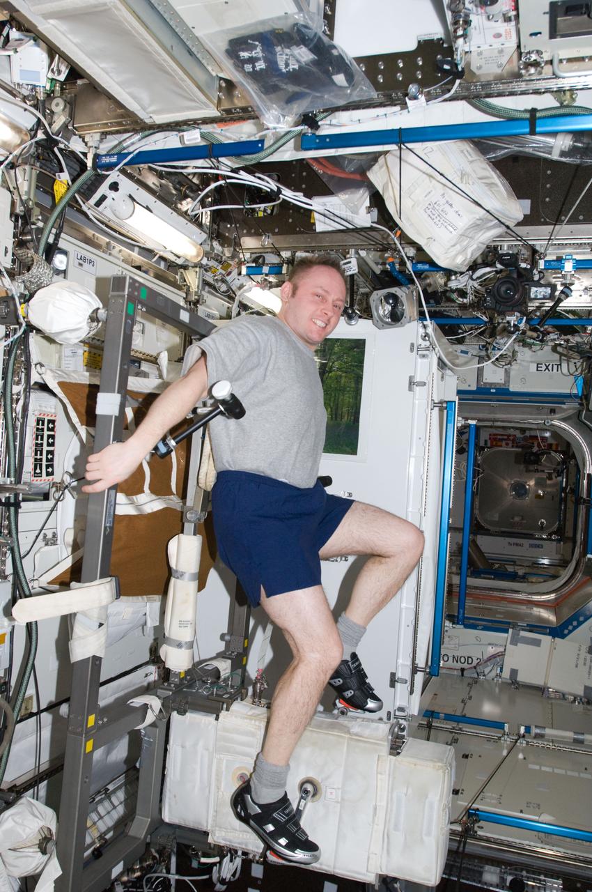 ISS018-E-043414 (26 March 2009) --- Astronaut Michael Fincke, Expedition 18 commander, exercises on the Cycle Ergometer with Vibration Isolation System (CEVIS) in the Destiny laboratory of the International Space Station.
