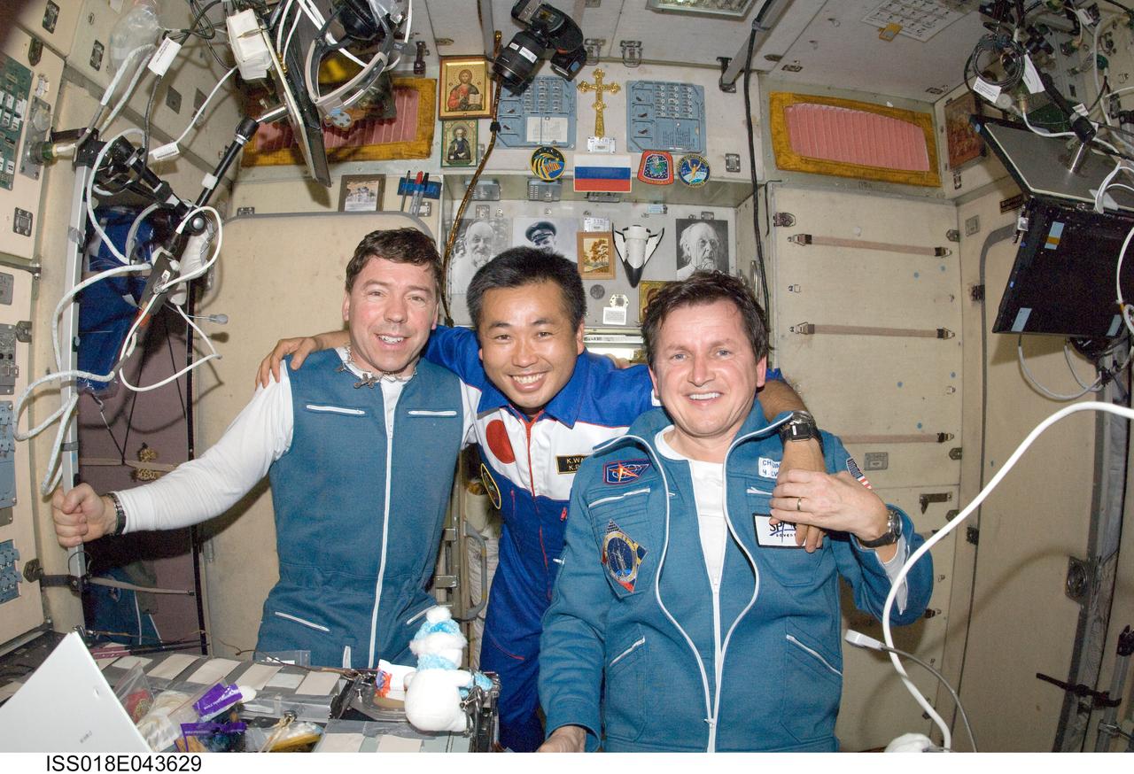ISS018-E-043629 (28 March 2009) --- NASA astronaut Michael Barratt (left), Expedition 19 flight engineer; Japan Aerospace Exploration Agency (JAXA) astronaut Koichi Wakata, Expedition 18/19 flight engineer; and U.S. spaceflight participant Charles Simonyi pose for a photo in the Zvezda Service Module of the International Space Station.