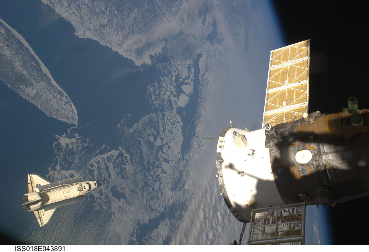 ISS018-E-043891 (25 March 2009) --- Backdropped by a colorful Earth, Space Shuttle Discovery (STS-119) is featured in this image photographed by an Expedition 18 crew member on the International Space Station soon after the shuttle and station began their post-undocking relative separation on March 25, 2009. The featured area is Anticosti Island, off the coast of Newfoundland.