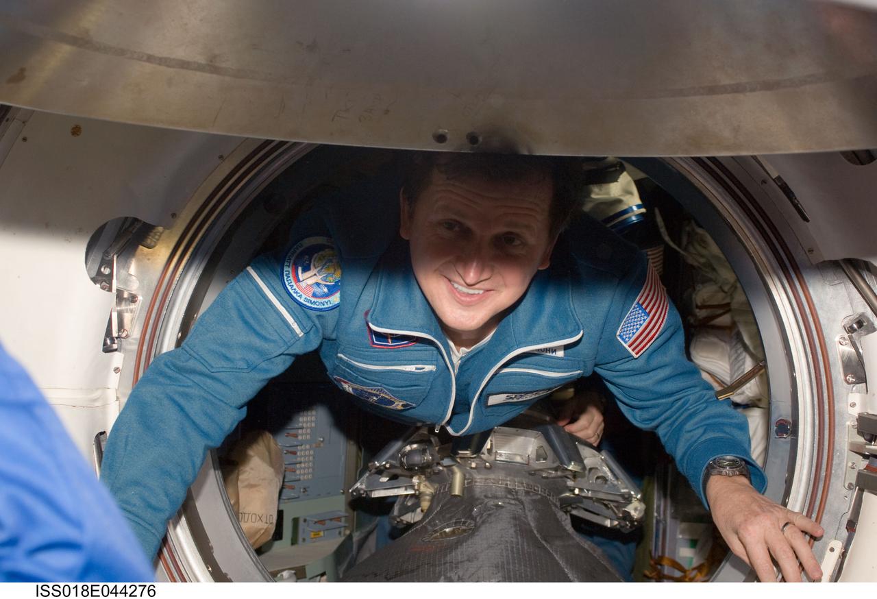 ISS018-E-044276 (28 March 2009) --- U.S. spaceflight participant Charles Simonyi ingresses the International Space Station after arriving onboard a Soyuz spacecraft with two Expedition 19 crewmembers (out of frame).