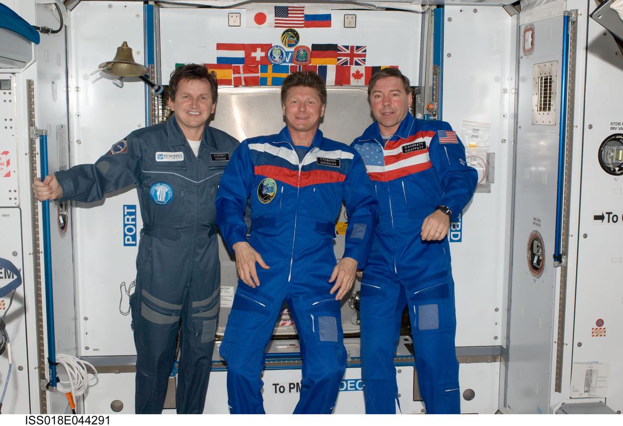 ISS018-E-044291 (1 April 2009) --- Cosmonaut Gennady Padalka (center), Expedition 19 commander; NASA astronaut Michael Barratt (right), Expedition 19 flight engineer; and U.S. spaceflight participant Charles Simonyi pose for a photo in the Harmony node of the International Space Station.