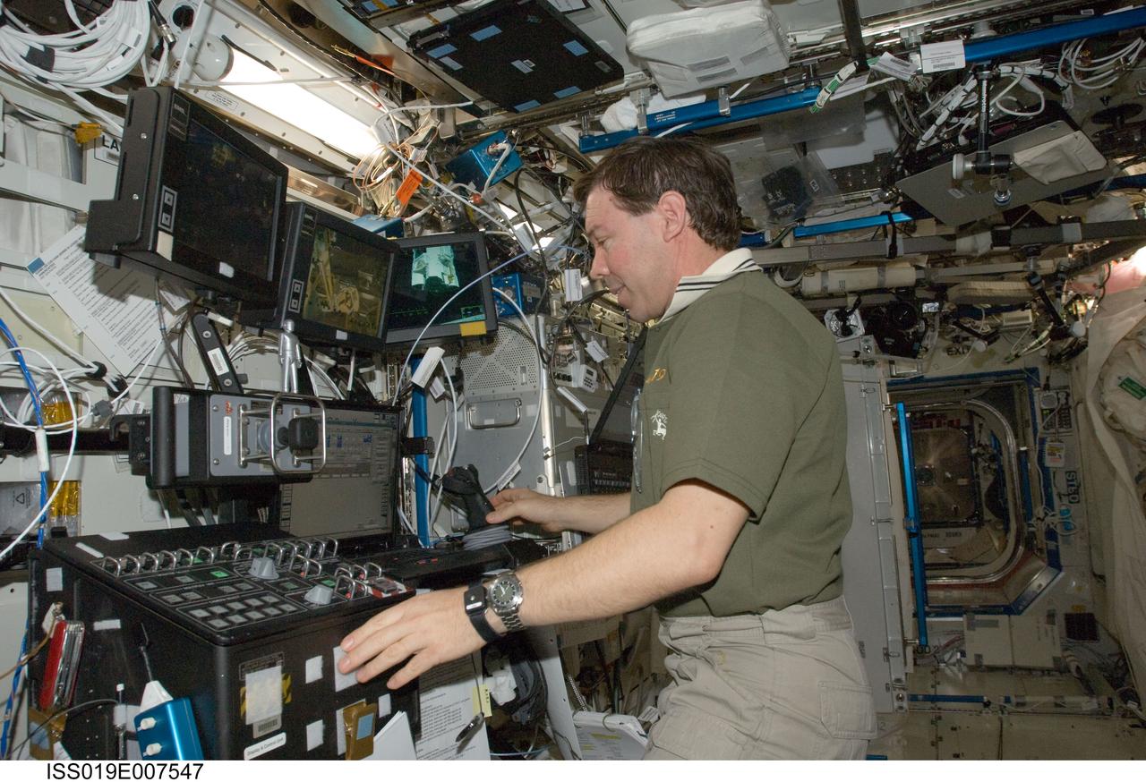 ISS019-E-007547 (17 April 2009) --- Astronaut Michael Barratt, Expedition 19/20 flight engineer, works the controls at the Canadarm2 robotic work station in the Destiny laboratory of the International Space Station.
