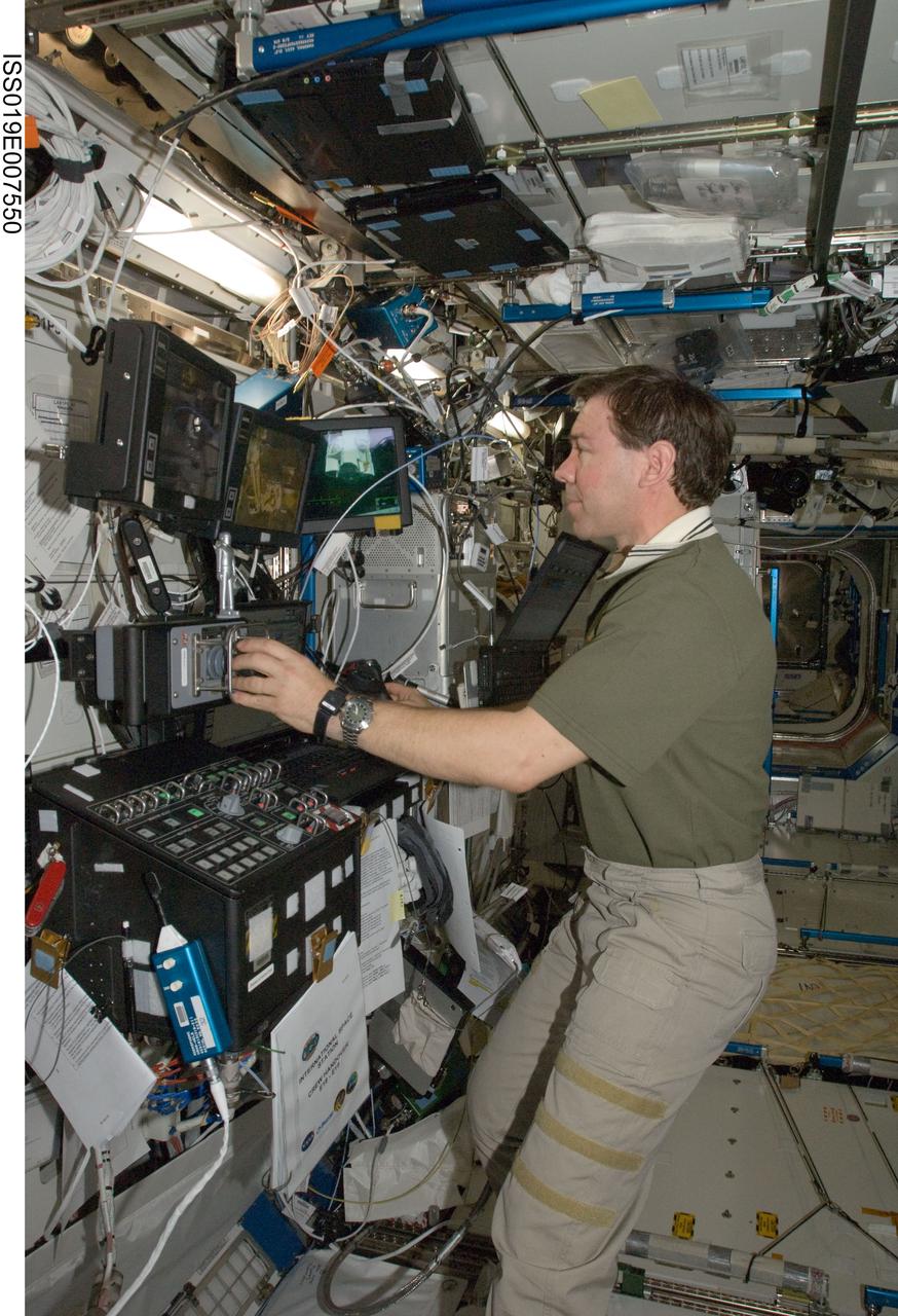 ISS019-E-007550 (17 April 2009) --- Astronaut Michael Barratt, Expedition 19/20 flight engineer, works the controls at the Canadarm2 robotic work station in the Destiny laboratory of the International Space Station.