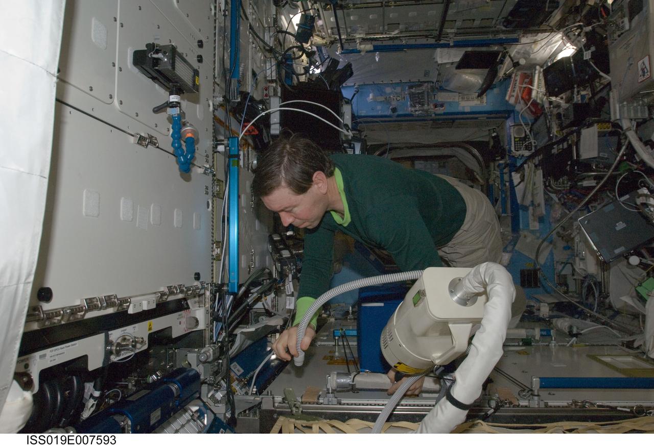 ISS019-E-007593 (18 April 2009) --- Astronaut Michael Barratt, Expedition 19/20 flight engineer, uses a vacuum cleaner during housekeeping operations in the Destiny laboratory of the International Space Station.