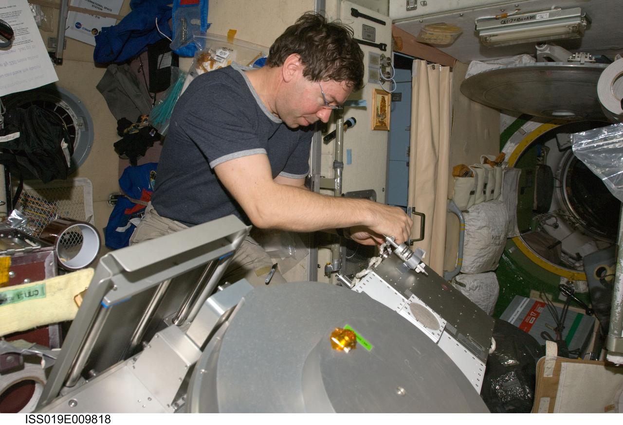 ISS019-E-009818 (23 April 2009) --- Astronaut Michael Barratt, Expedition 19/20 flight engineer, performs in-flight maintenance on the Treadmill Vibration Isolation System (TVIS) in the Zvezda Service Module of the International Space Station.