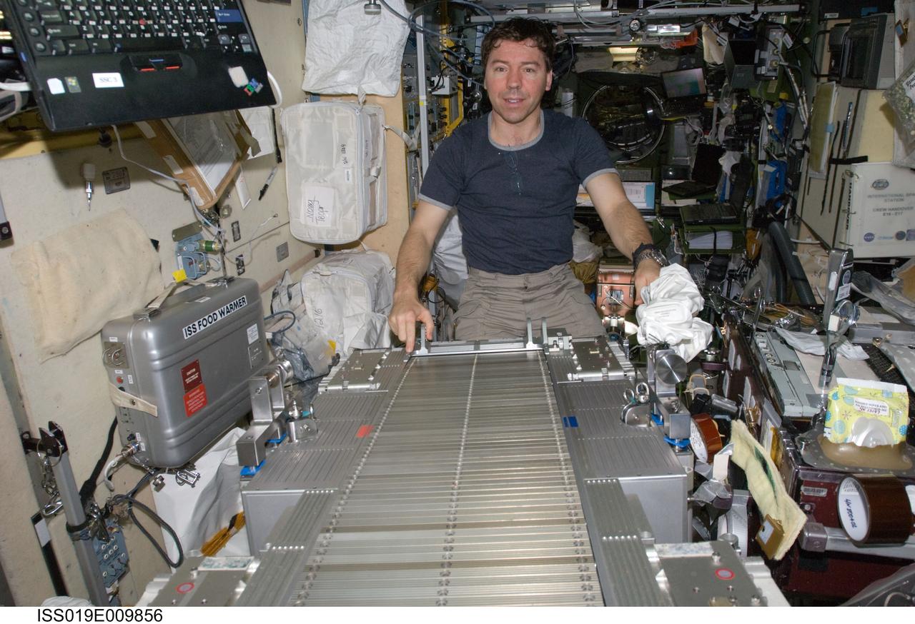 ISS019-E-009856 (23 April 2009) --- Astronaut Michael Barratt, Expedition 19/20 flight engineer, performs in-flight maintenance on the Treadmill Vibration Isolation System (TVIS) in the Zvezda Service Module of the International Space Station.