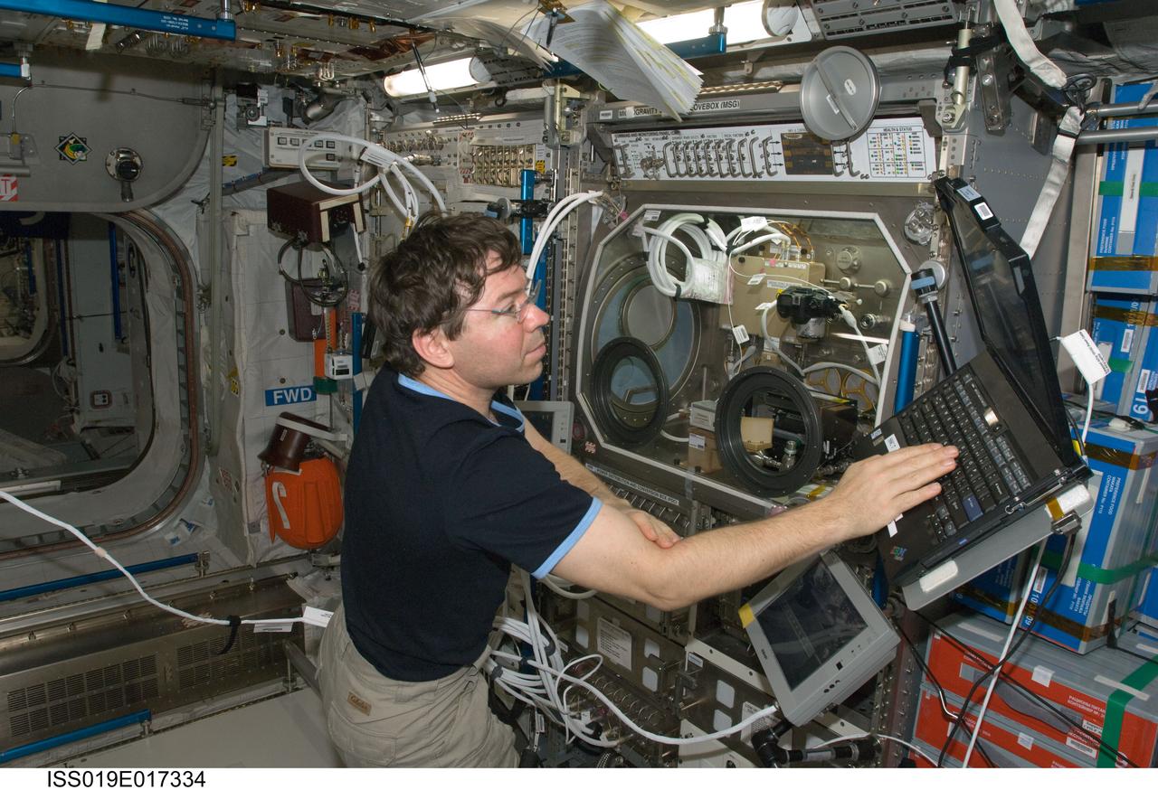 ISS019-E-017334 (16 May 2009) --- Astronaut Michael Barratt, Expedition 19/20 flight engineer, uses a computer near the Microgravity Science Glovebox (MSG) in the Columbus laboratory of the International Space Station.