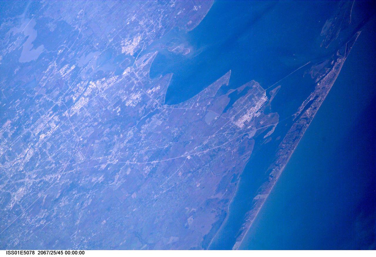 ISS01-E-5078 (December 2000) --- A northwesterly-looking view from over the Gulf of Mexico reveals much of Galveston and Harris Counties, as photographed with a digital still camera from the Earth-orbiting International Space Station (ISS). Galveston Island and Galveston Bay take up most of the right side of the frame, with parts of southern Harris County and even part of north Harris County, including Lake Houston, are visible on the left side of the frame. The Texas City Dike is in the upper right quadrant of the image.