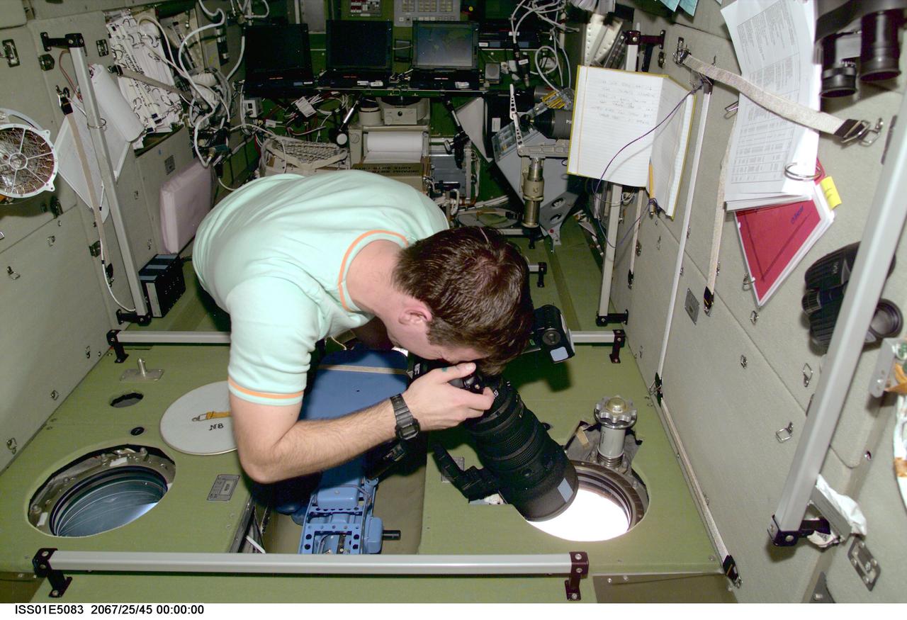 ISS01-E-5083 (December 2000) --- Cosmonaut Yuri P. Gidzenko, Expedition One Soyuz commander, takes a still photo of a geographic target of opportunity,  through one of the viewing ports onboard  the International Space Station's Zvezda Service Module.