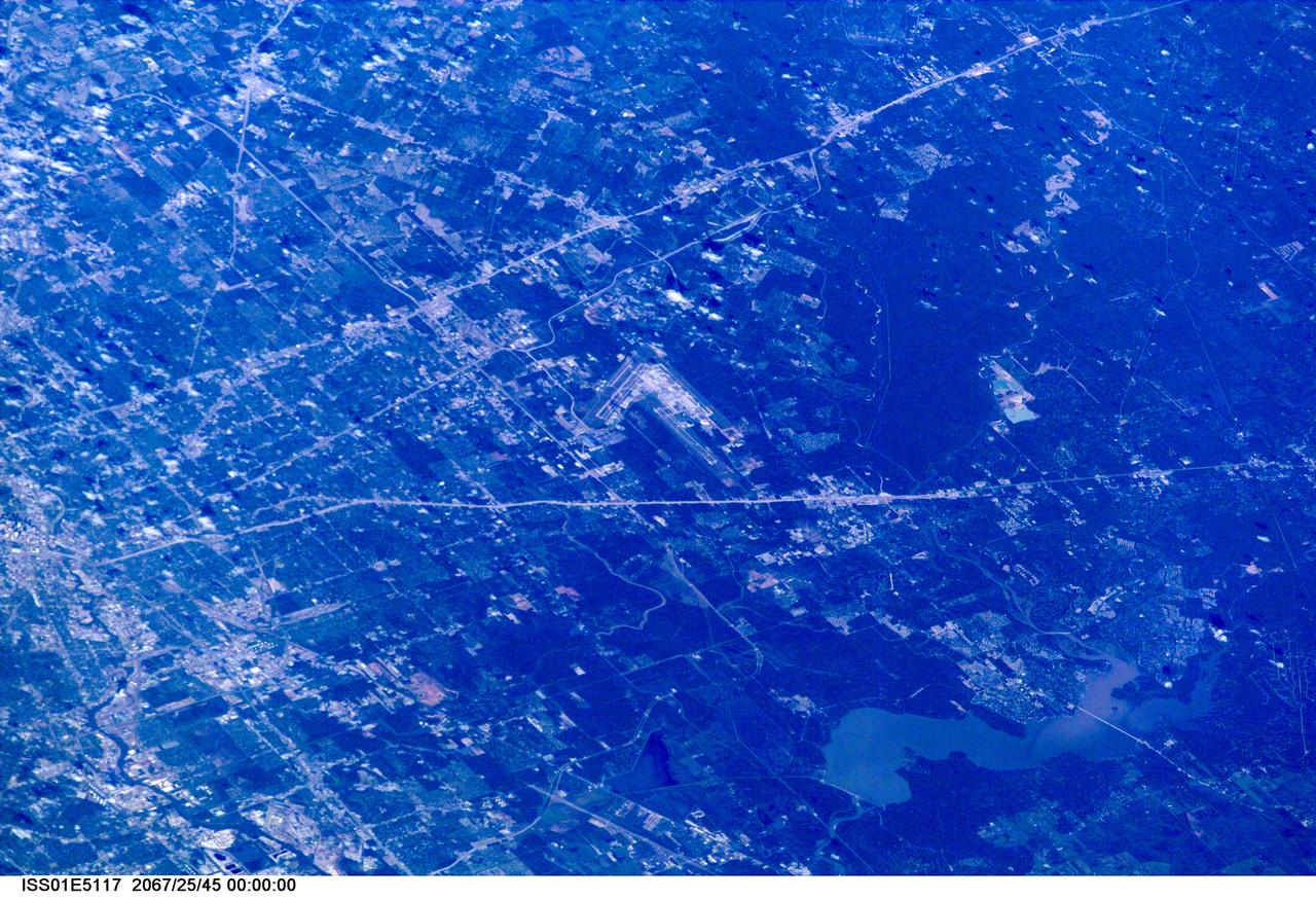 ISS01-E-5117 (December 2000) --- This westerly-looking view over north Harris County featuring Lake Houston and the Bush Intercontinental Airport was photographed with a digital still camera from the Earth-orbiting International Space Station (ISS). Parts of the 610 Loop, Interstate Highway 45, U.S. Highway 59 and the Sam Houston Toll Way can be easily delineated in the view. Part of the downtown area is just below center at left edge of the frame.