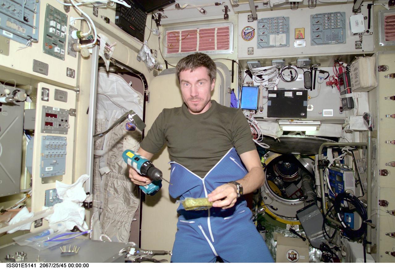 ISS01-E-5141 (December 2000) ---  Cosmonaut Sergei K. Krikalev, Expedition One flight engineer, combines work and eating in the Zvezda service module aboard the Earth-orbiting International Space Station (ISS).  The picture was recorded with a digital still camera.