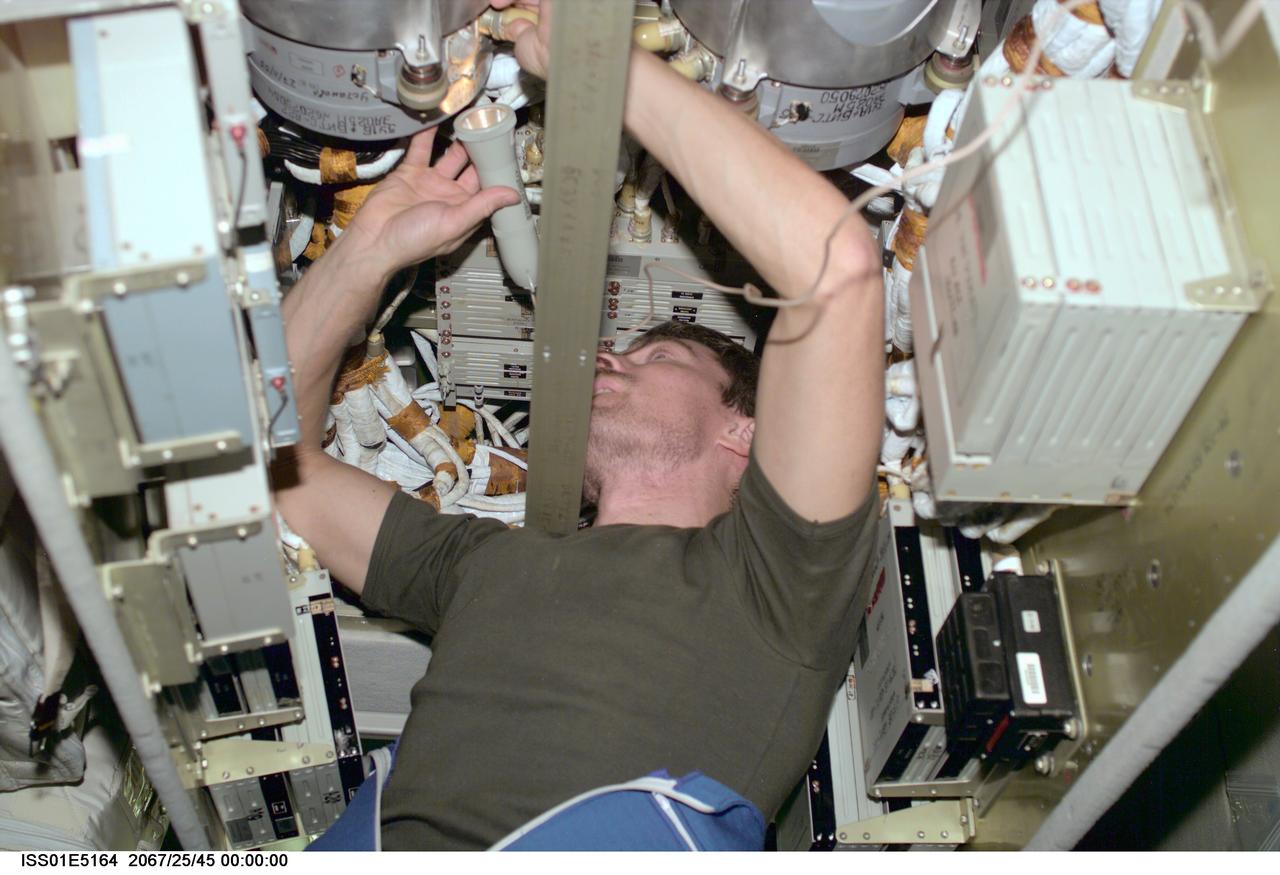 ISS01-E-5164 (December 2000) --- Inside the International Space Station's Zvezda Service Module, cosmonaut Sergei K. Krikalev, Expedition One flight engineer, uses a flashlight to check connections on a memory device in the telemetry system for the station.