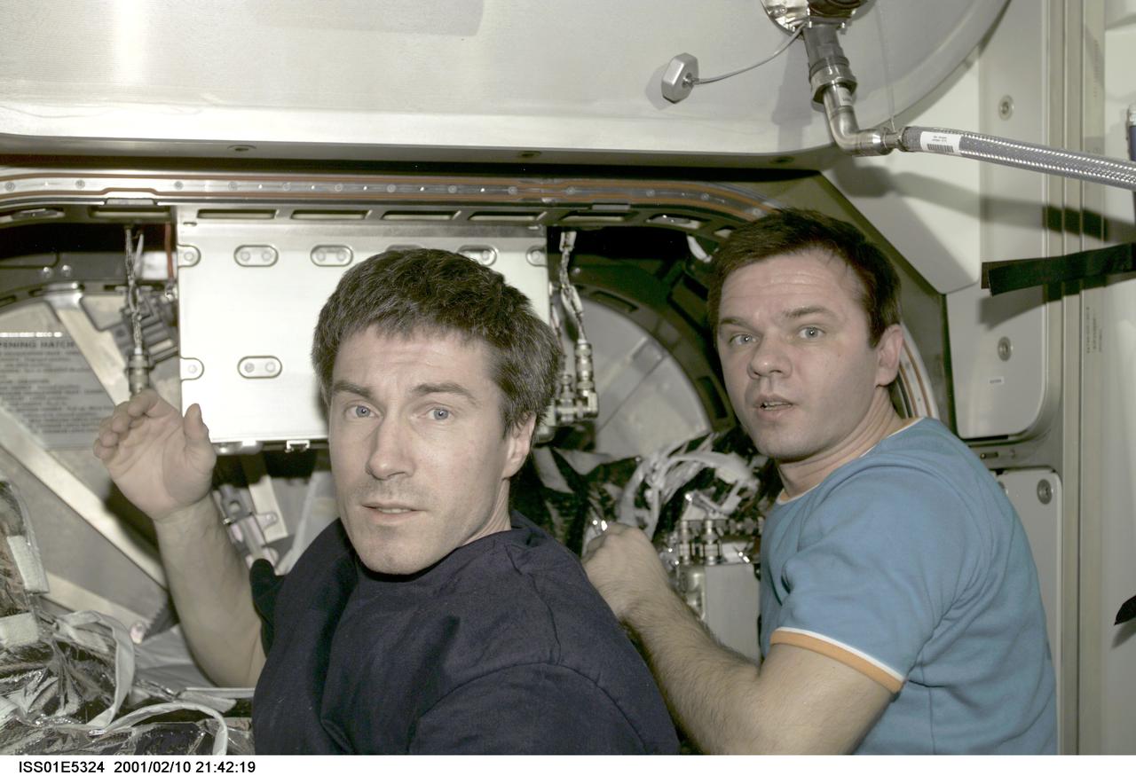 ISS-01-E-5324 (10 February 2001) ---  Cosmonauts Sergei K. Krikalev (left), Expedition One flight engineer, and  Yuri P. Gidzenko, Soyuz commander,  are pictured at the hatch that leads from the Unity node into the newly attached Destiny laboratory.  The picture was recorded with a digital still camera on the day the hatch was initially opened.