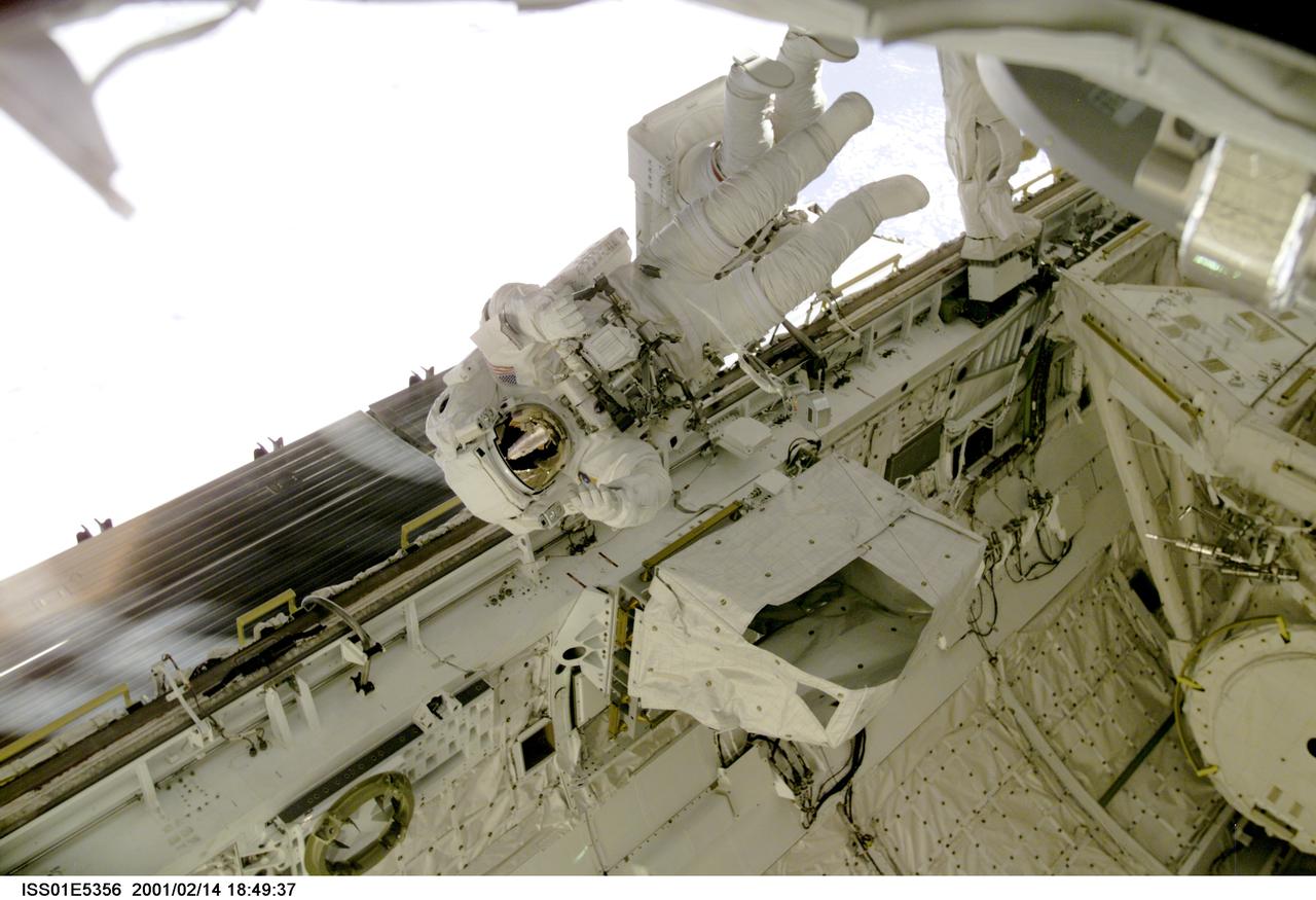 ISS01-E-5356 (14 February 2001) ---   Astronaut Robert L. Curbeam, STS-98 mission specialist, floats above the longerons of the cargo bay on the Space   Shuttle Atlantis during the final of three STS-98/5a space walks.  Partially  obscured behind Curbeam is astronaut Thomas D. Jones, his colleague and partner for all three walks.  The scene was recorded with a digital still camera.