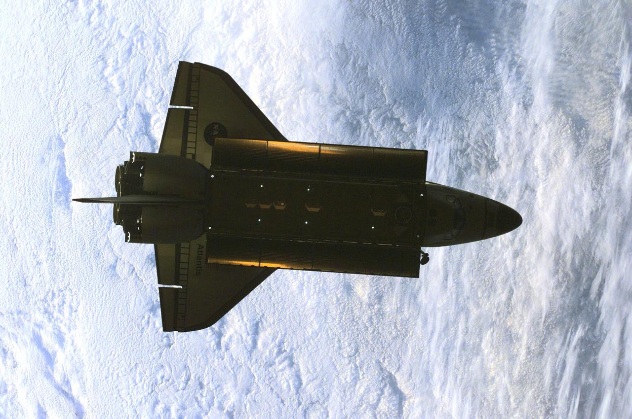 ISS01-E-5386 (16 February 2001) --- This partially silhouetted nadir image of the Space Shuttle Atlantis was photographed by the three-man Expedition One crew aboard the International Space Station (ISS) shortly after the shuttle and the outpost unlinked following several days of joint operations of the two crews. The scene, backdropped against a mass of white clouds on Earth, was recorded with a digital still camera.